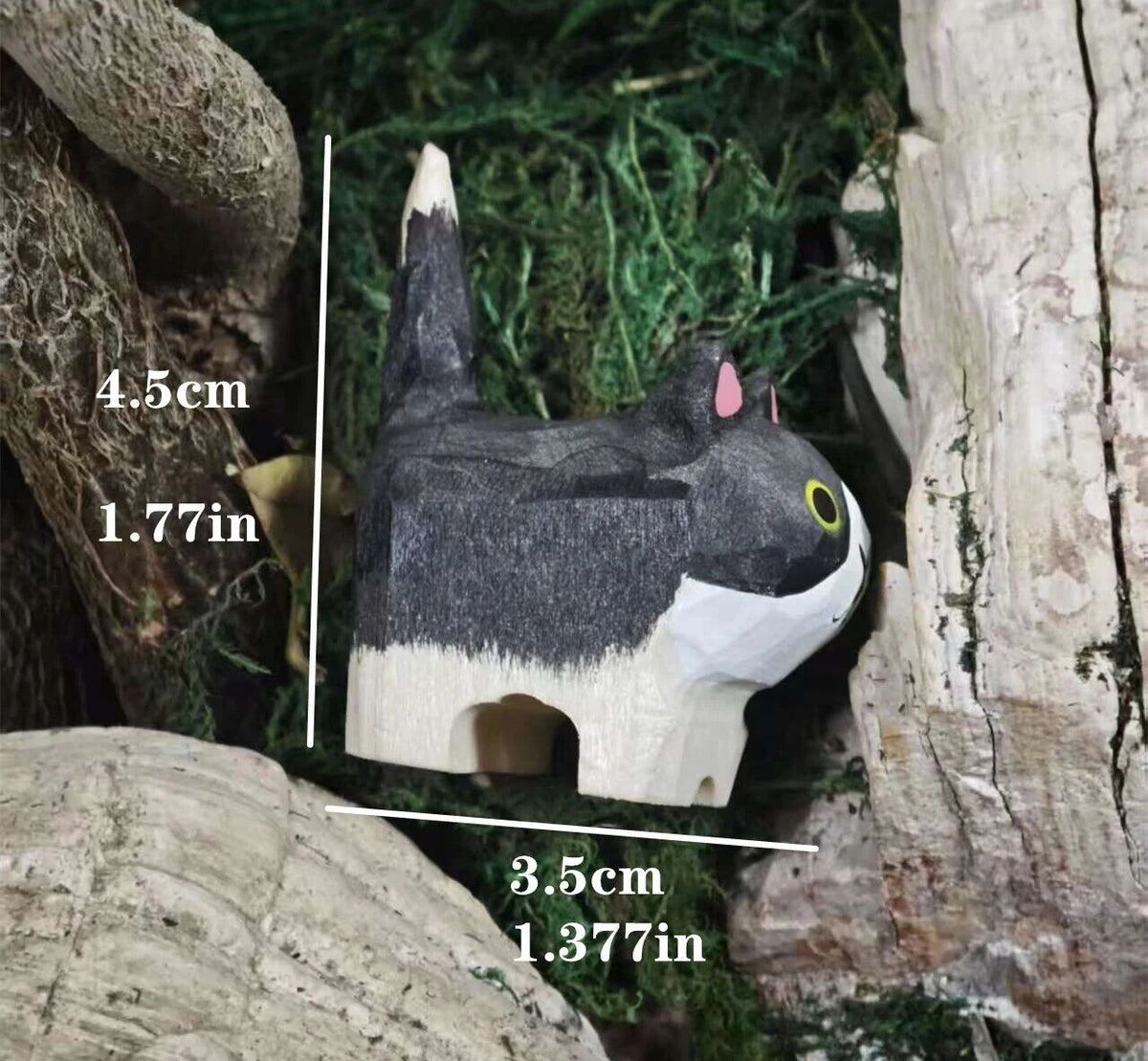A small carved cat figurine or toy shown between tree trunks with measurement labels overlaid: 4.5 cm tall and 3.