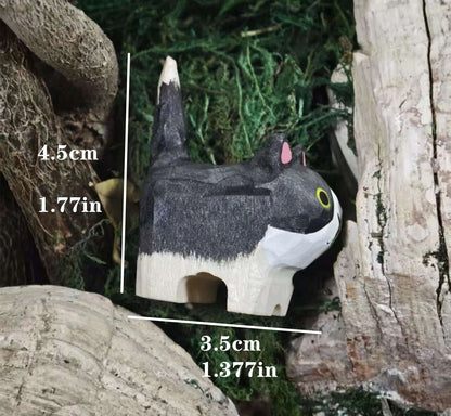 A small carved cat figurine or toy shown between tree trunks with measurement labels overlaid: 4.5 cm tall and 3.
