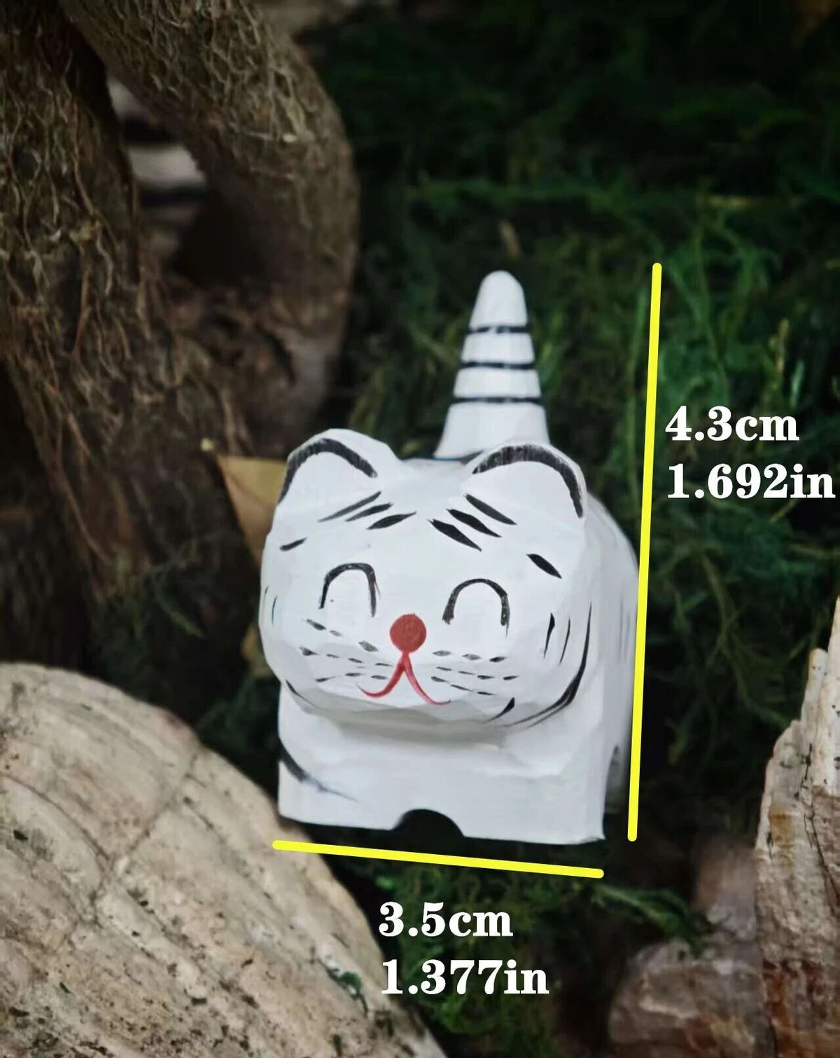 A small white tiger figurine or decorative cat statue shown outdoors among logs and greenery, with yellow measurement lines and text indicating dimensions 4.3 cm tall and 3.